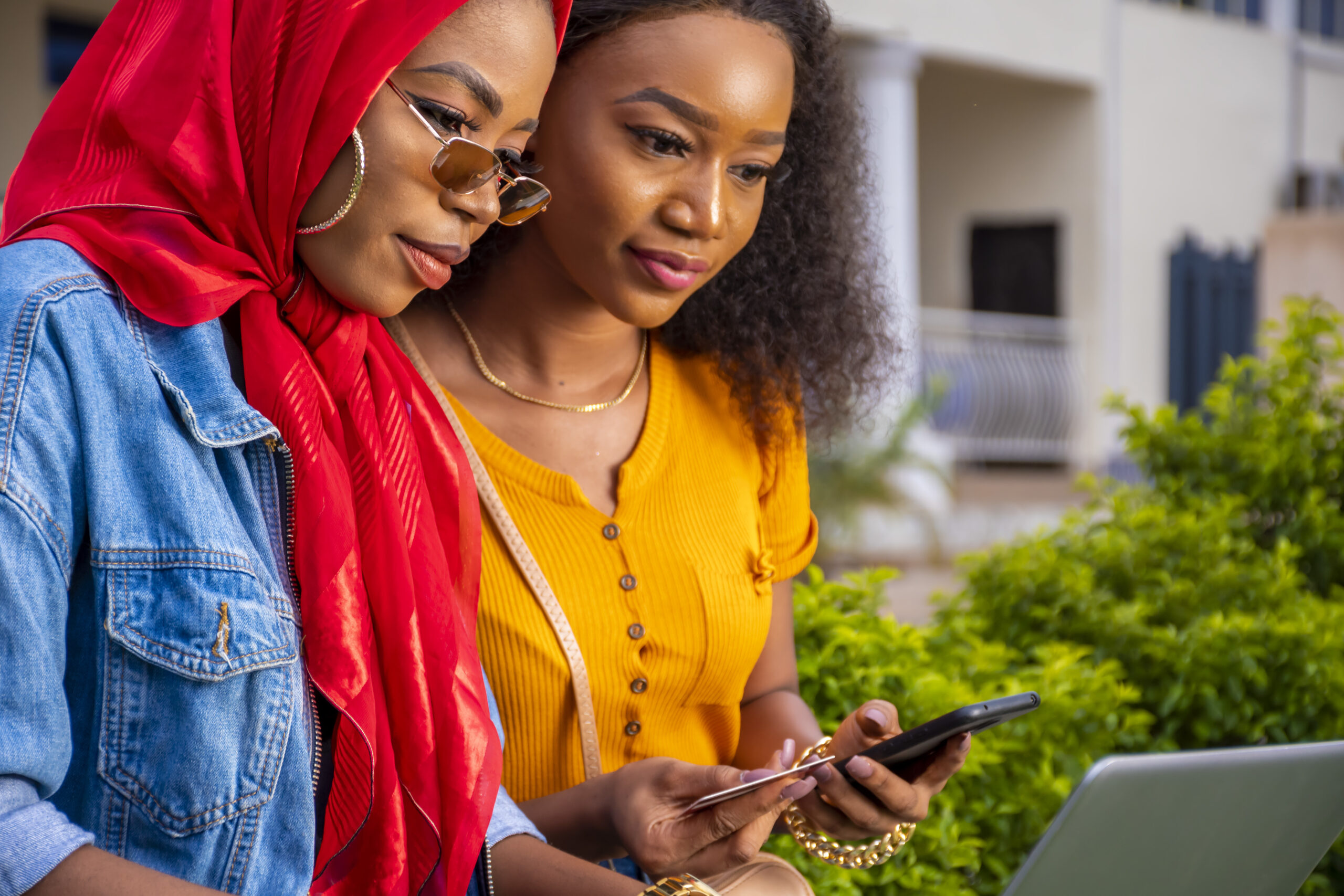 African females shopping online while sitting in a park
